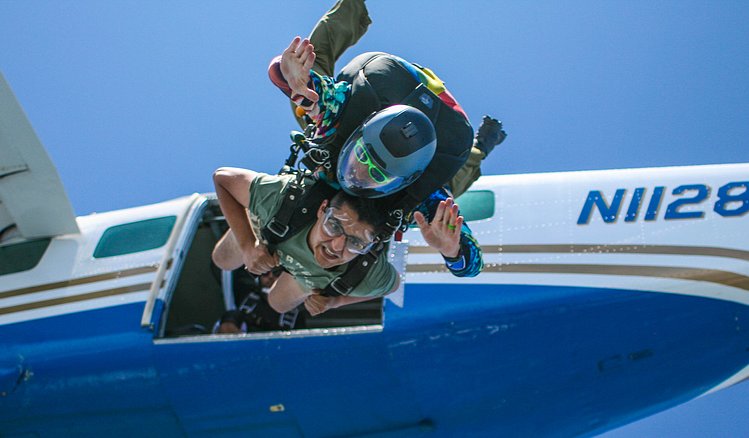 Skydiver exitting jump plane, tandem skydiver