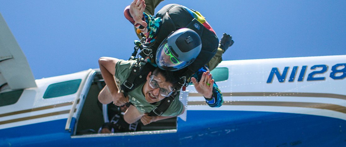 Skydiver exitting jump plane, tandem skydiver