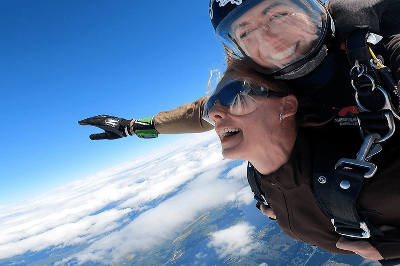 two female skydivers in tandem freefall over the ottawa river in ontario